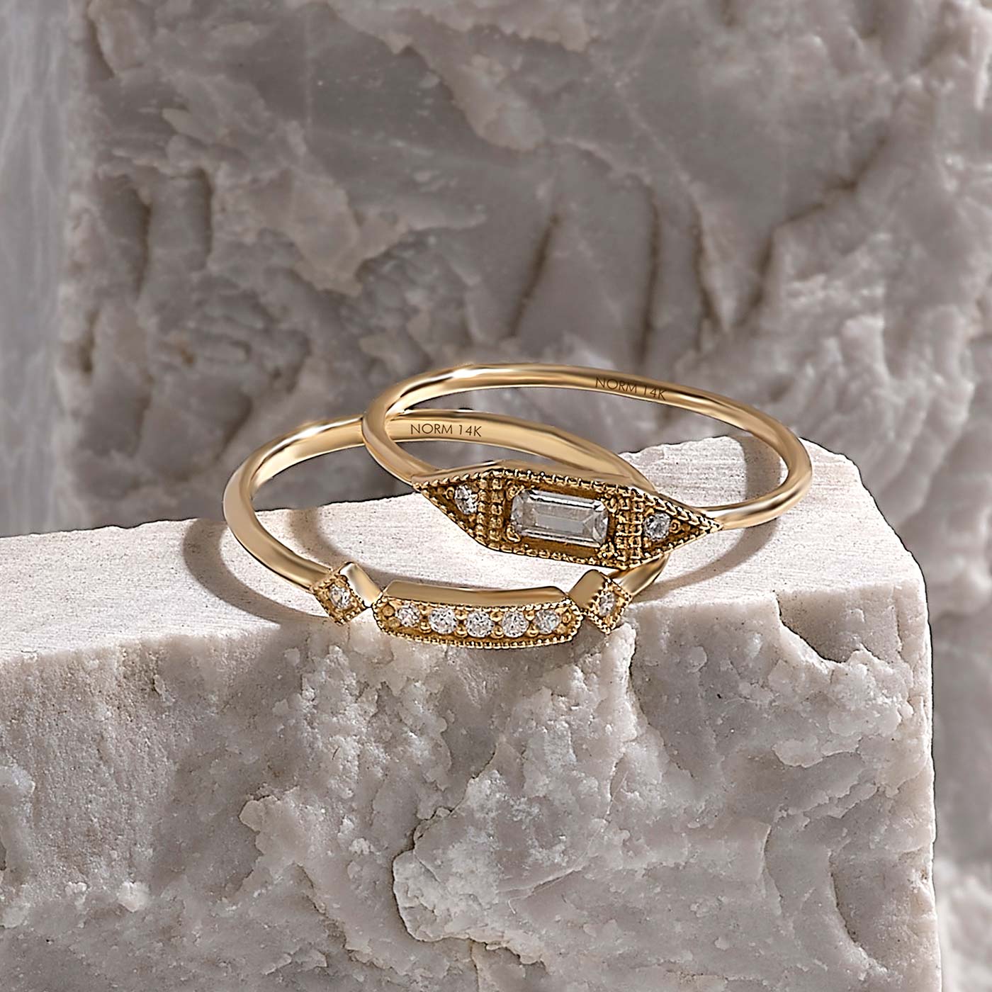 Norm Solid Gold and Diamond Rings on Marble